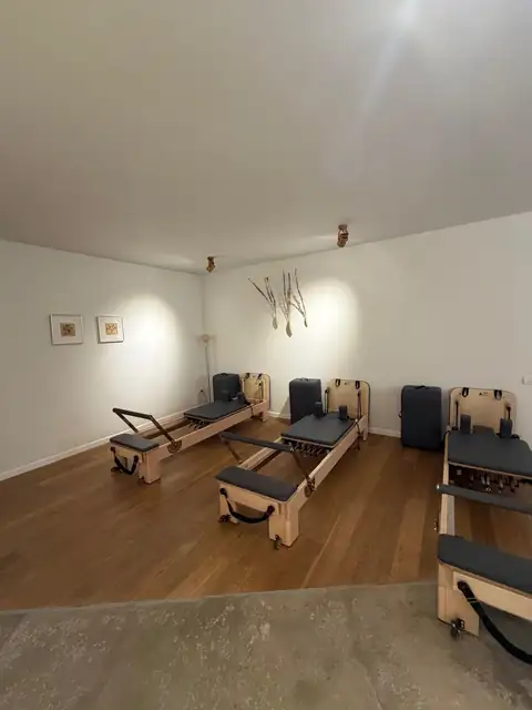 שלושה רפורמרים מעץ בסטודיו פילאטיס שקט ומעוצב